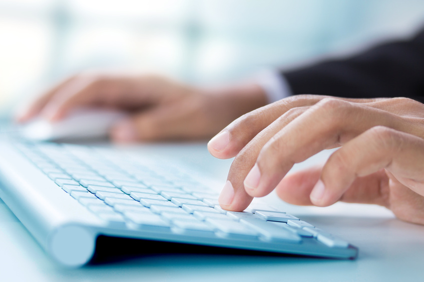 Business hand touching computer keys during work